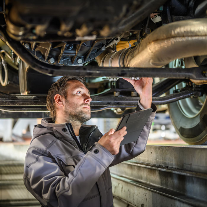 mechanic inspecting car undercarriage